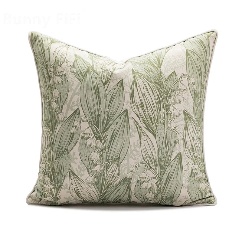 Decorative pillow with green leaf pattern on a white background