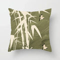 Decorative pillow with bamboo and bird design on a green background