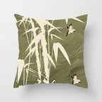 Decorative pillow with bamboo and bird design on a green background
