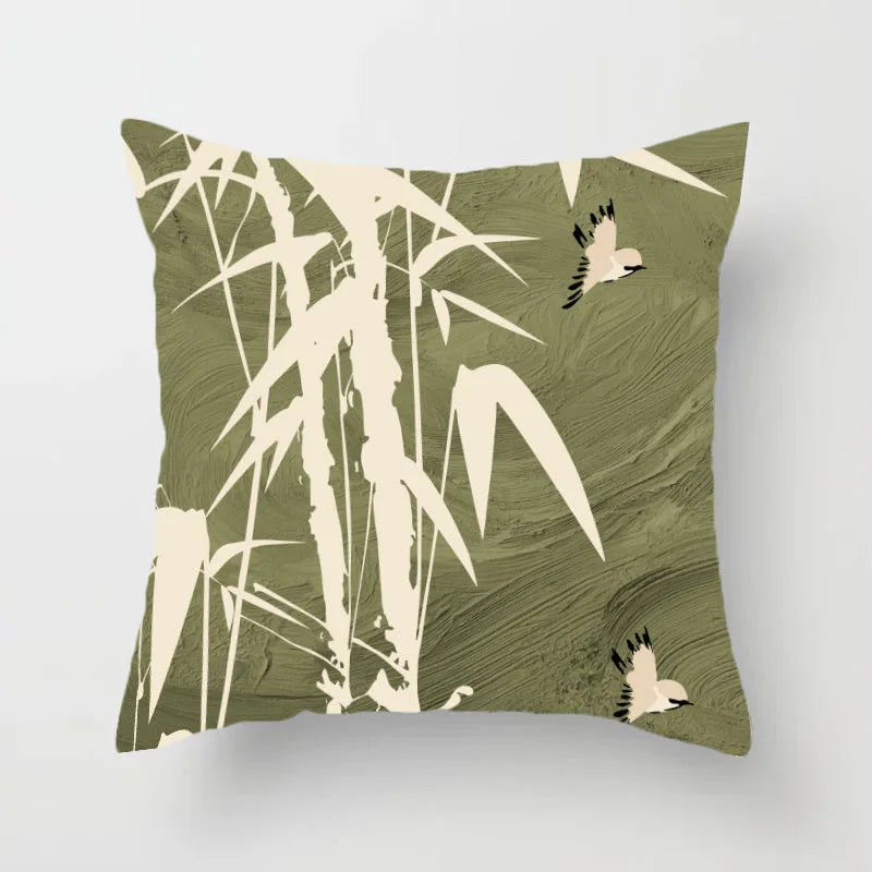 Decorative pillow with bamboo and bird design on a green background