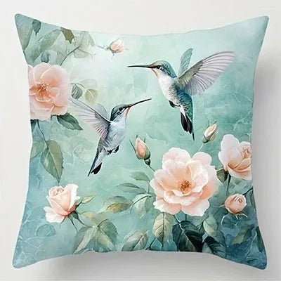Decorative pillow with hummingbirds and flowers on a light blue background