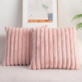 Pink textured throw pillow on a sofa with a neutral background