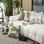 Decorative pillows on a white sofa with a plant and Marshall speaker in a room.