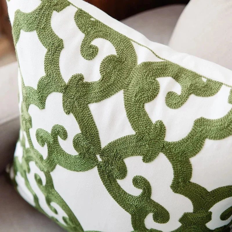 Close-up of a decorative pillow with green geometric pattern on white background