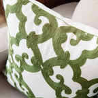 Close-up of a decorative pillow with green geometric pattern on white background