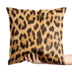 Leopard print pillow held by a hand on a white background