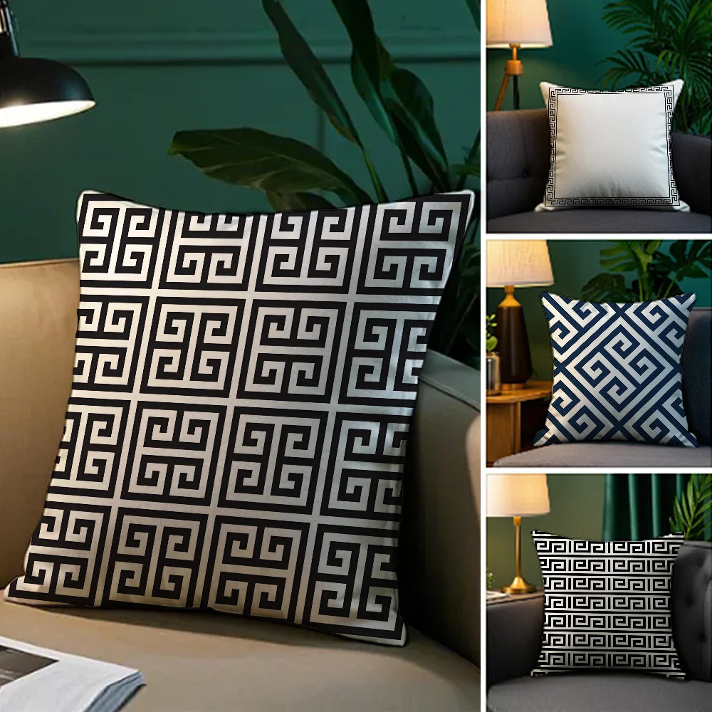 Decorative pillow with Greek key pattern on a sofa against a green wall.
