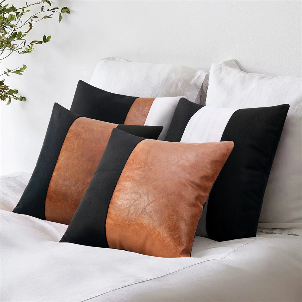 Set of leather and fabric pillows on a bed with a white background