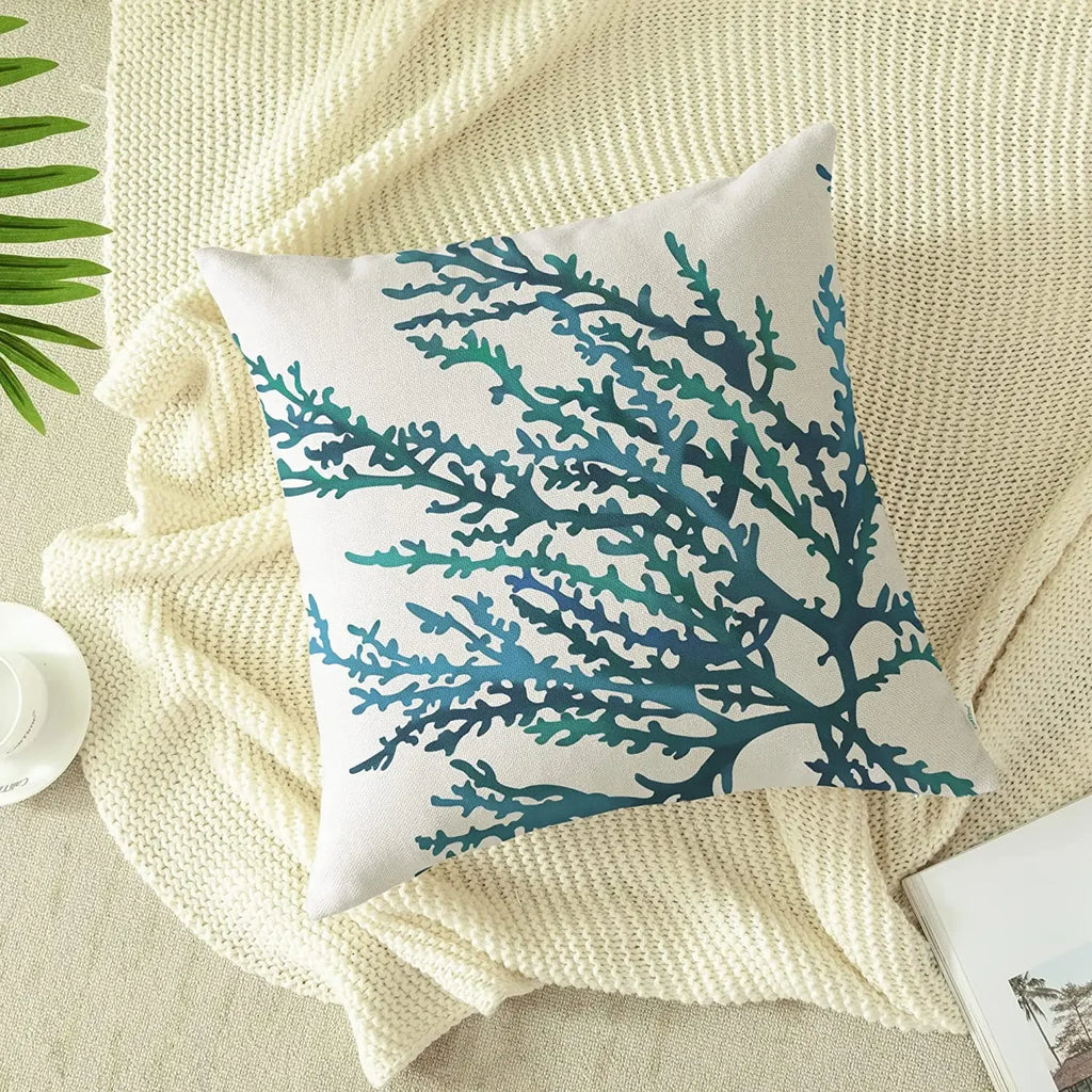 Decorative pillow with blue coral pattern on a beige surface
