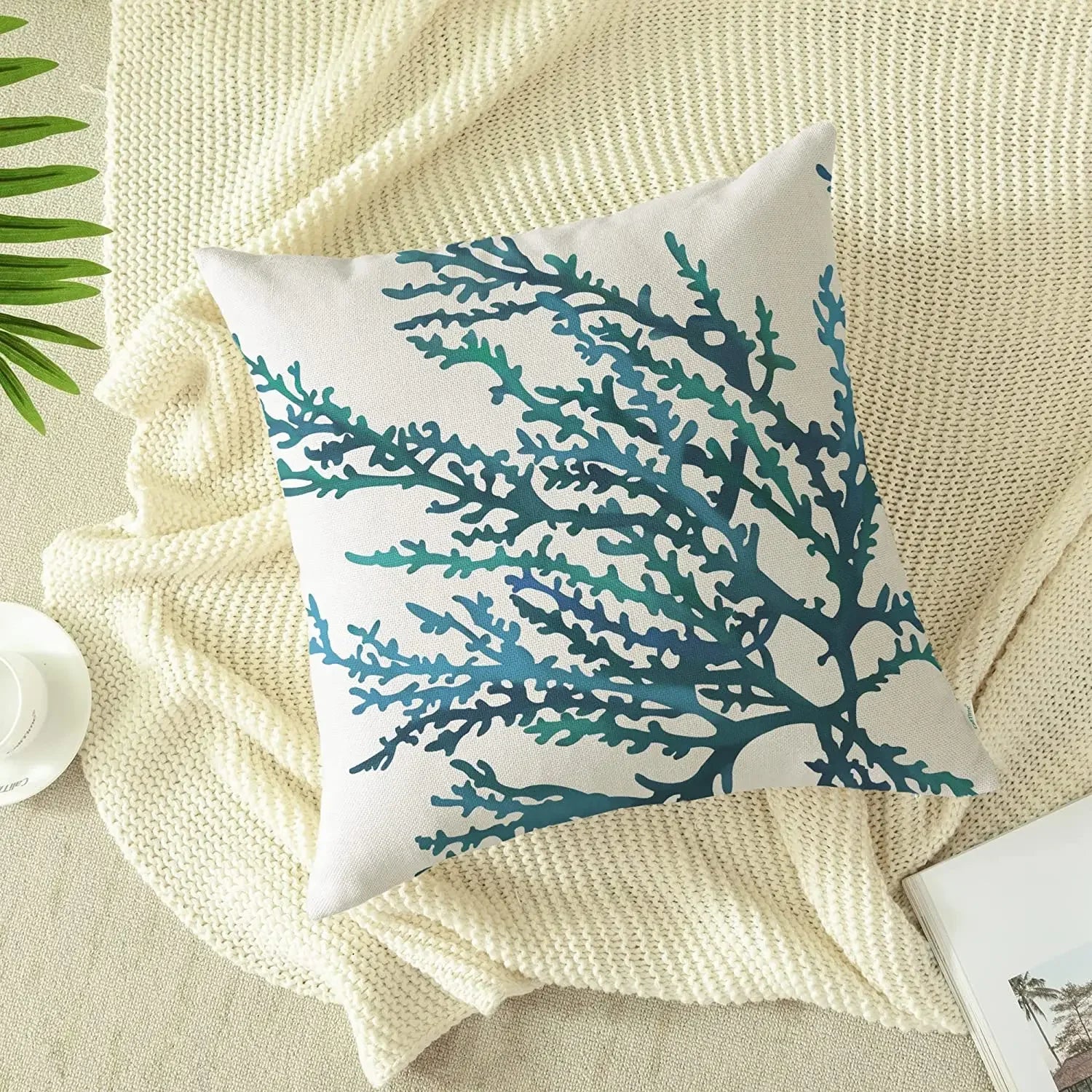Decorative pillow with blue coral pattern on a beige surface