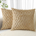 Two beige patterned pillows on a couch with a neutral background