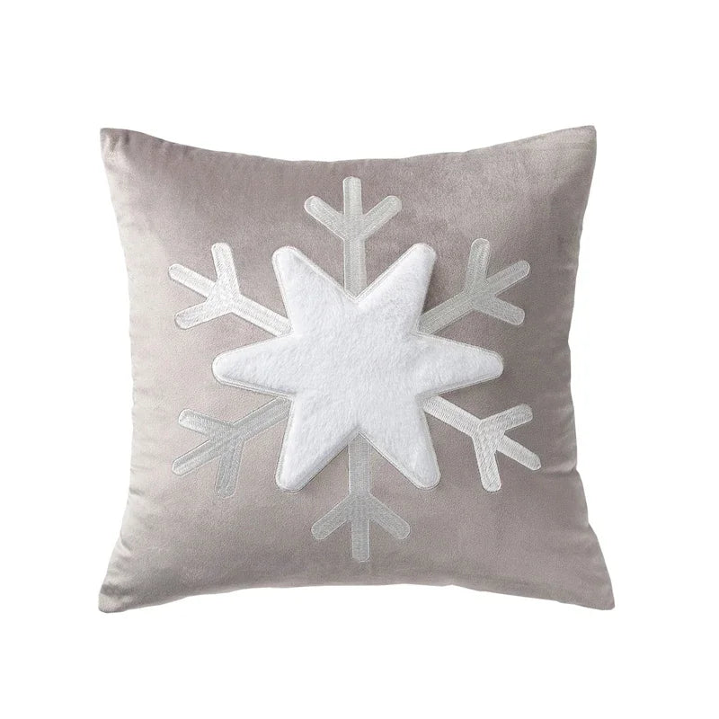 Gray pillow with a large white snowflake design on a white background