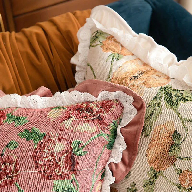 Floral-patterned cushions with lace trim held by a person.