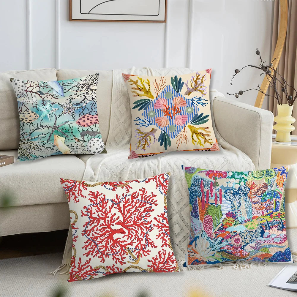 Set of ocean-themed pillow covers with coral, starfish, and tropical patterns on sofa