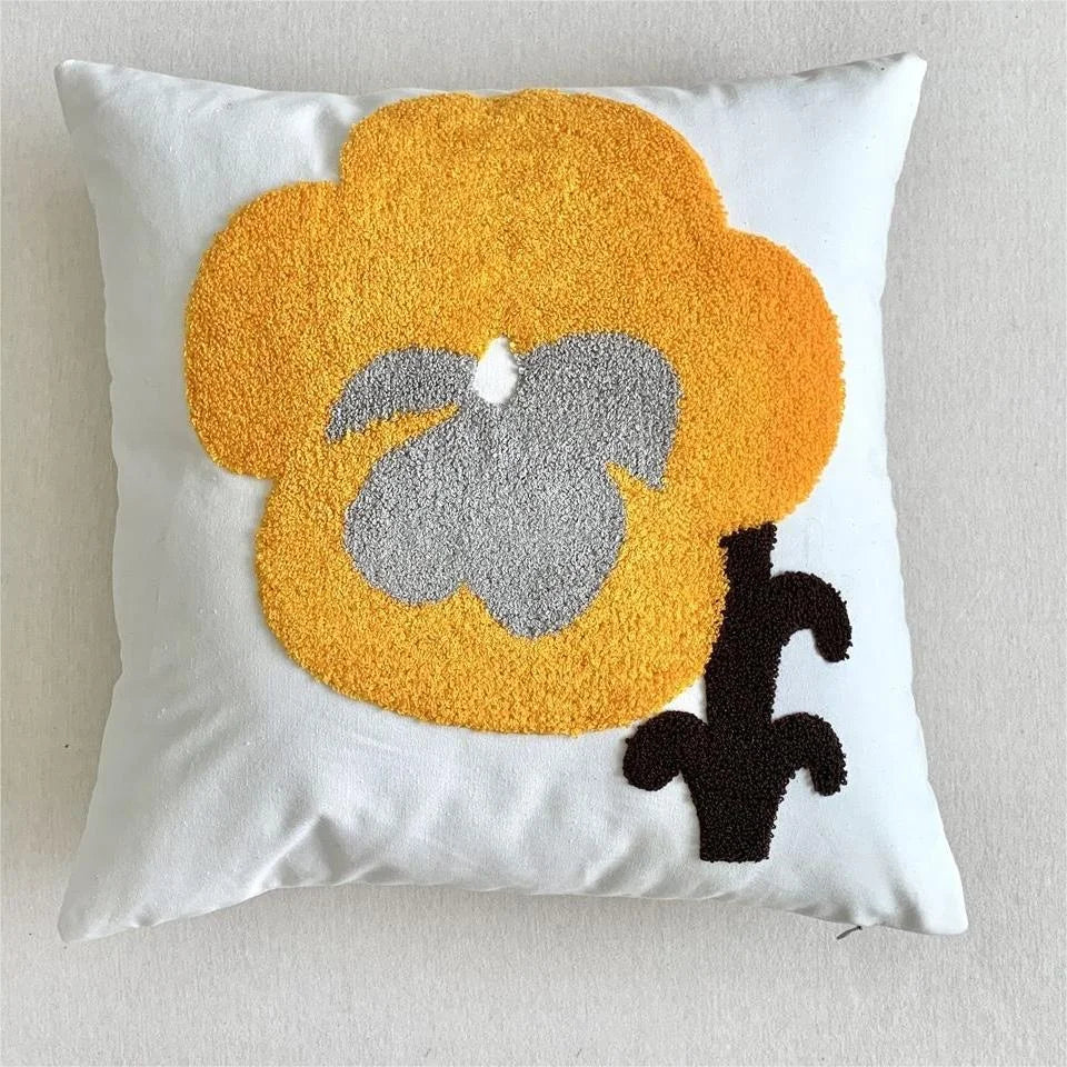 Decorative pillow with a yellow and gray abstract design on a white background
