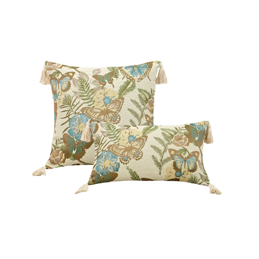 Two decorative pillows with butterfly and floral pattern on a white background