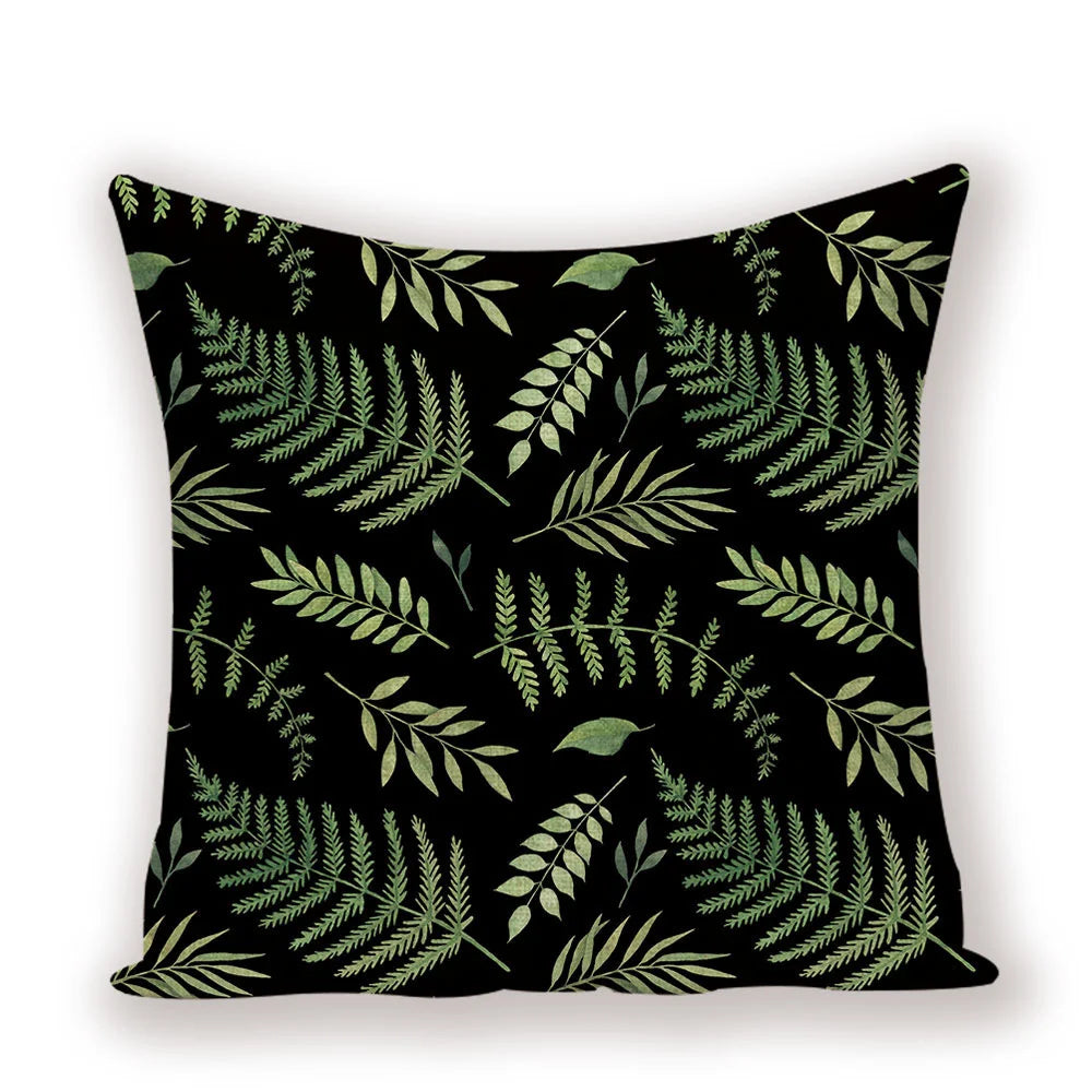 Decorative pillow with green leaf pattern on a black background