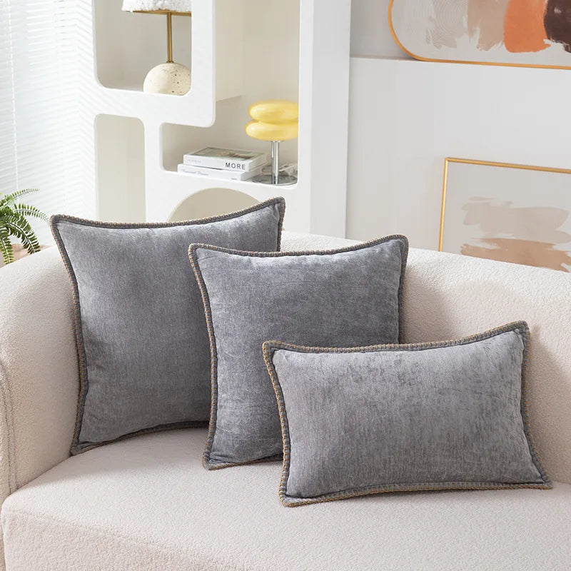 Gray velvet pillows on a beige sofa with a modern interior background