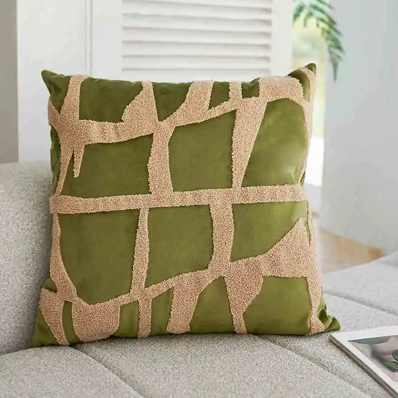 Green pillow with beige geometric pattern on a couch