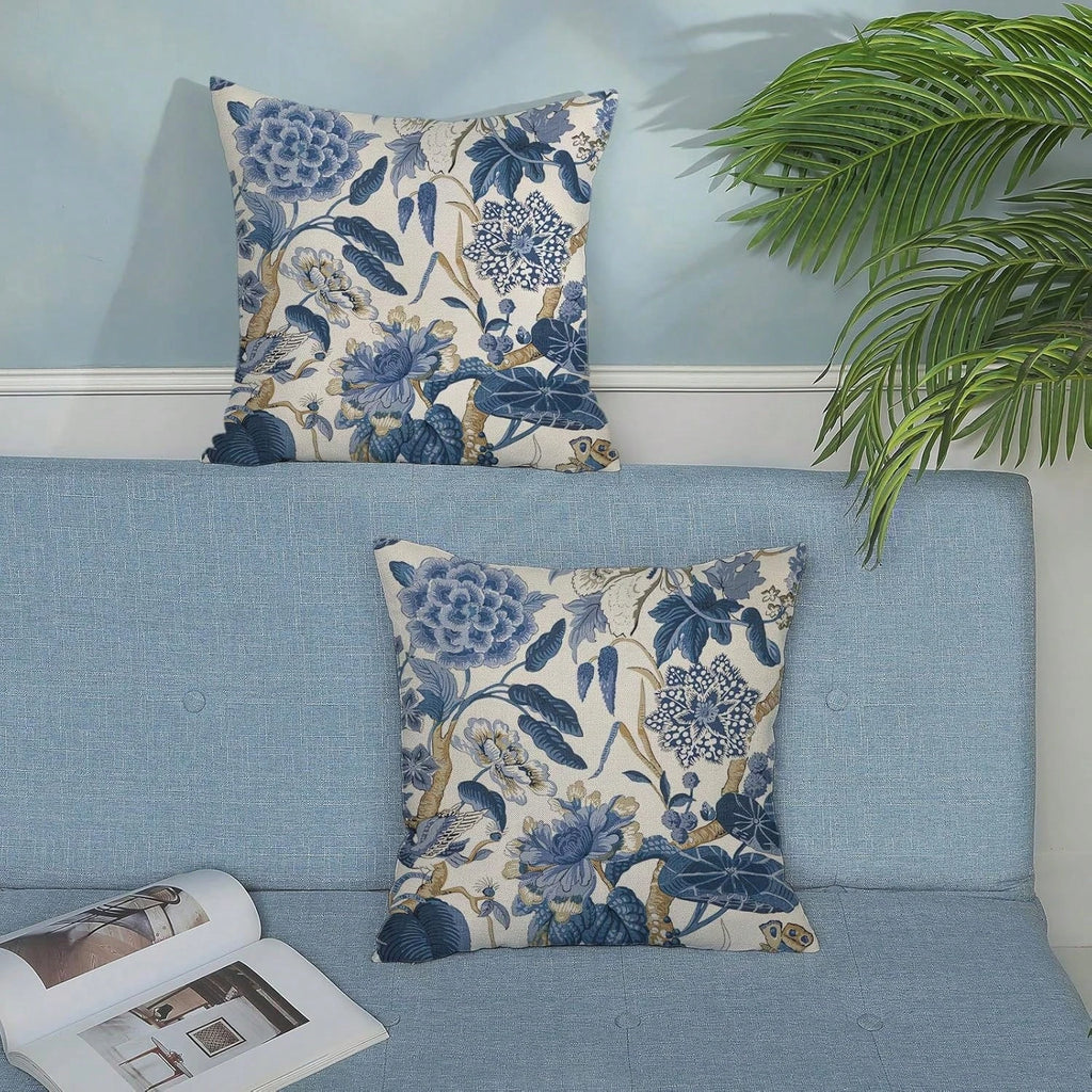 Floral patterned pillows on a blue sofa with a plant in the background