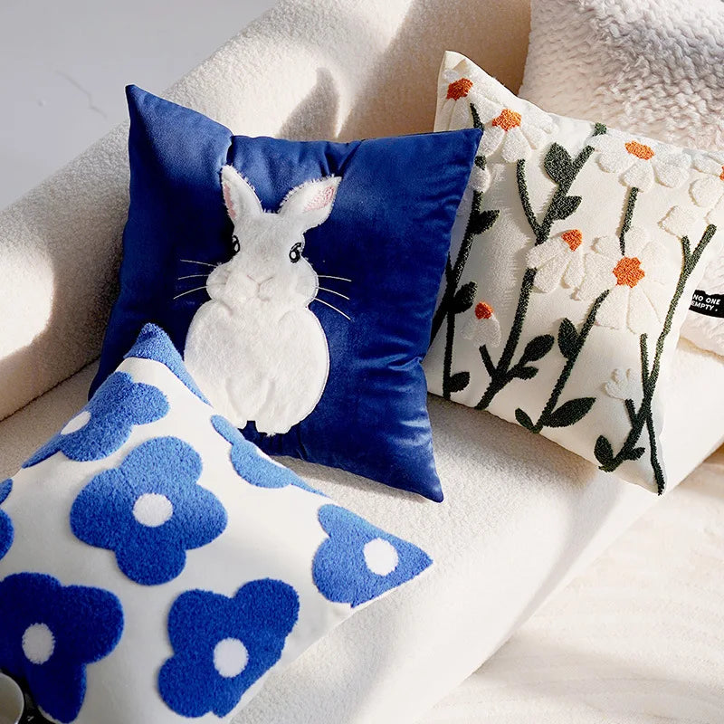 Three decorative pillows with different patterns on a light-colored sofa.