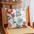 Floral-patterned pillow on a wooden chair with a wicker seat