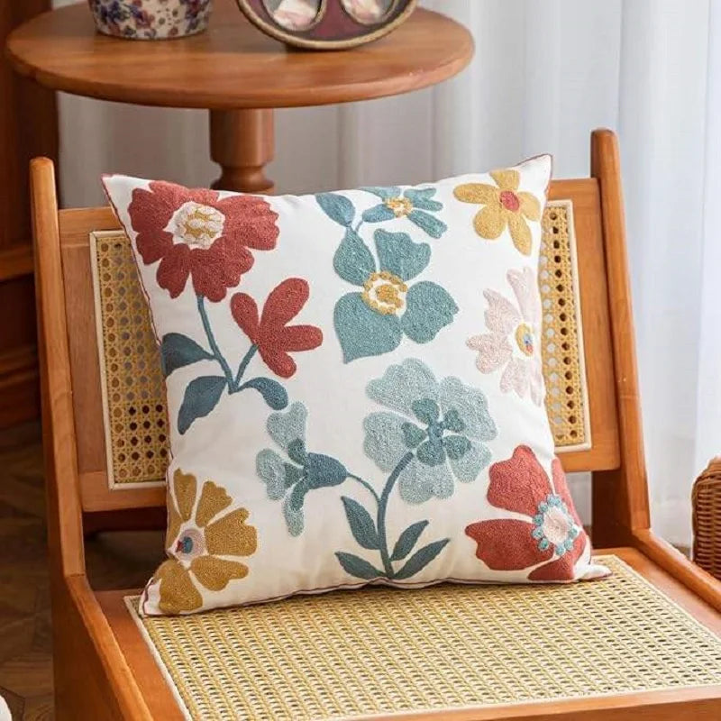 Floral-patterned pillow on a wooden chair with a wicker seat