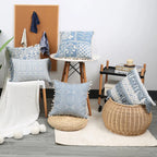 Decorative blue patterned pillows on a chair and floor in a room setting.