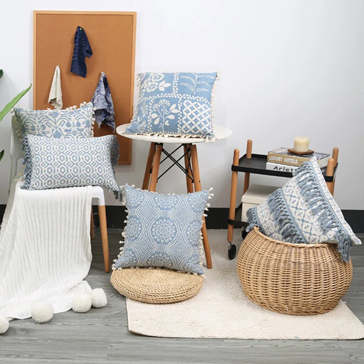 Decorative blue patterned pillows on a chair and floor in a room setting.