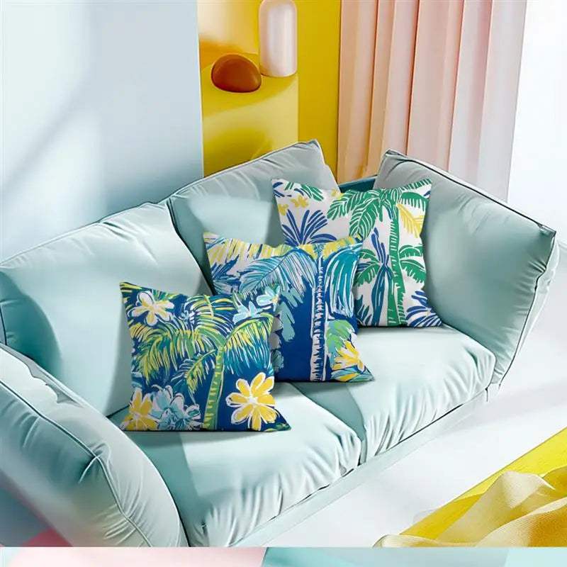 Light blue sofa with colorful palm leaf patterned cushions against a bright yellow wall.