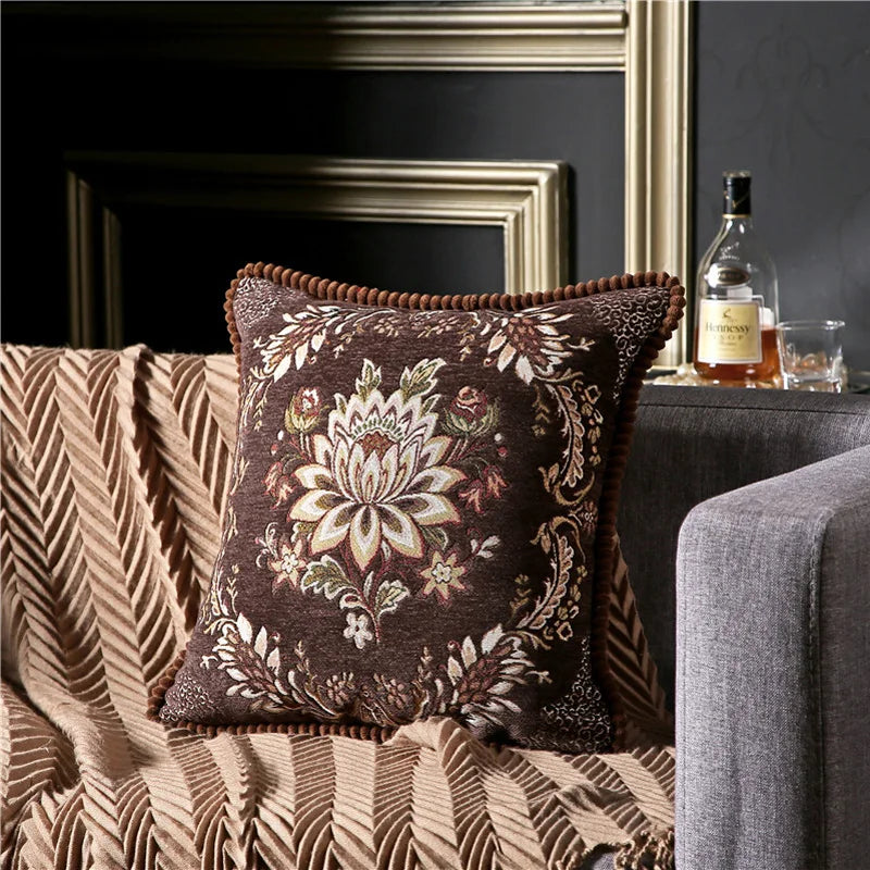 Decorative pillow with floral pattern on a couch in a living room setting.