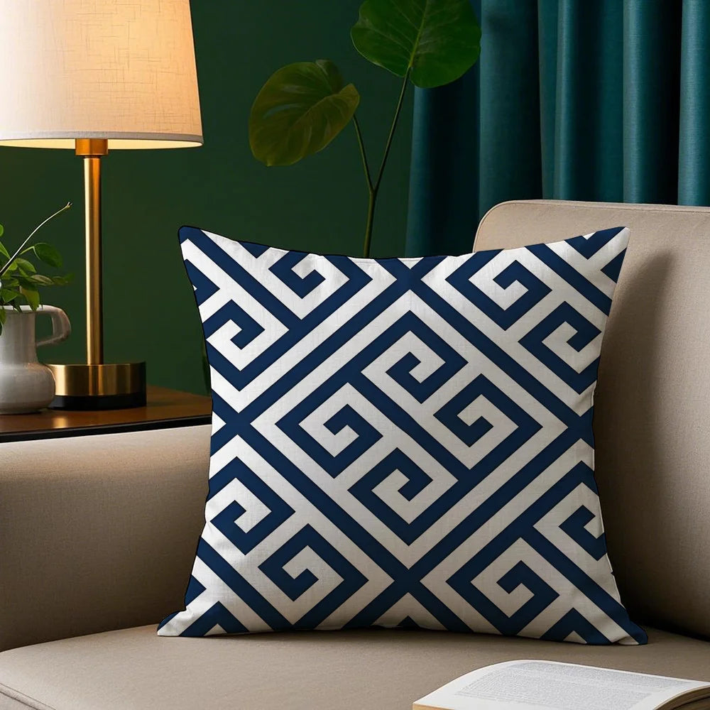 Decorative pillow with blue and white pattern on a beige sofa against a green wall.