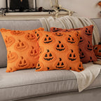 Orange pillows with jack-o'-lantern patterns on a gray couch.