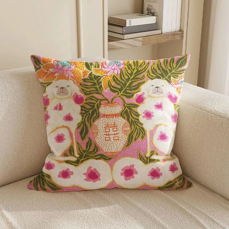 Decorative pillow with floral and animal design on a beige couch.