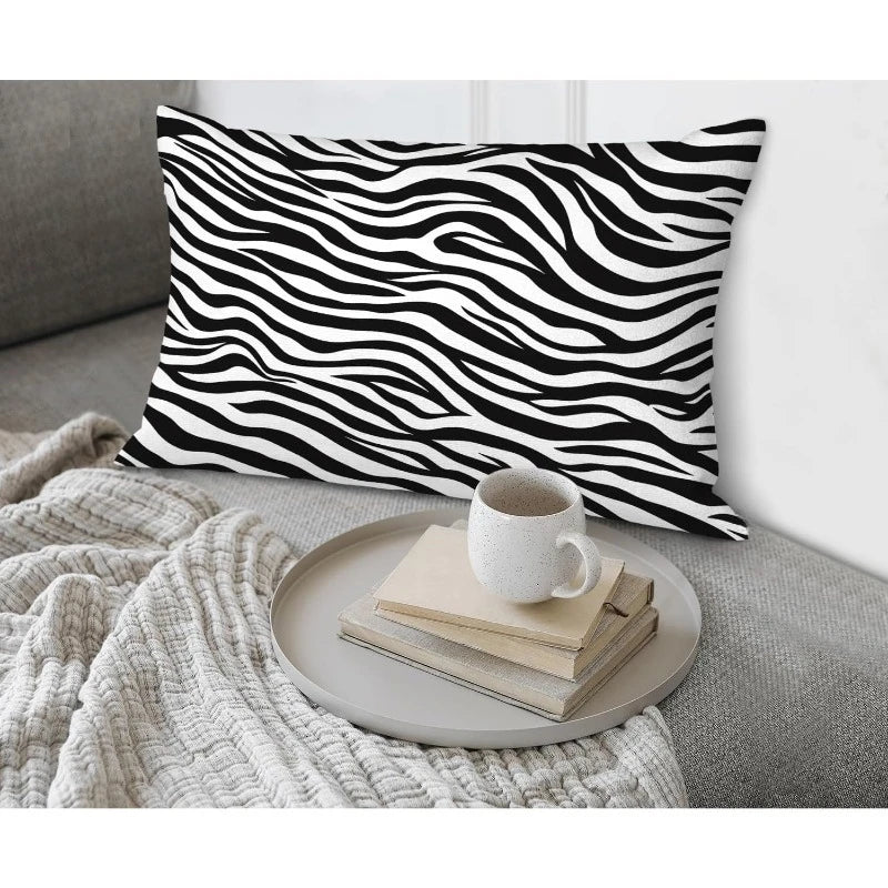 Zebra print pillow on a couch with a coffee cup and books on a tray.