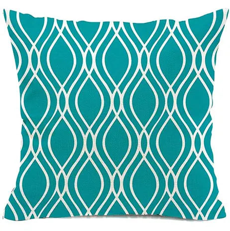 Teal pillow with white geometric pattern on a white background