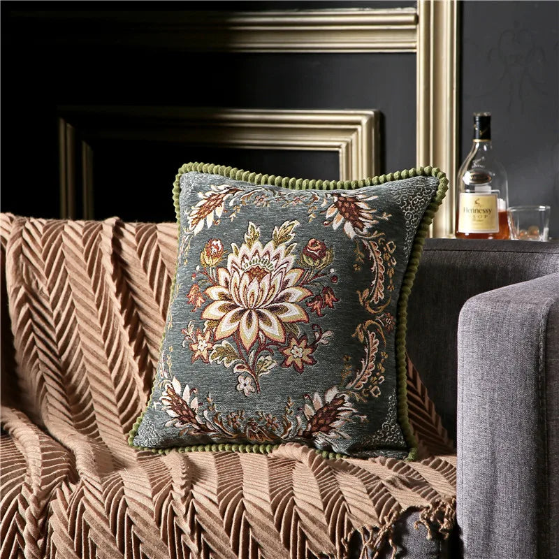 Decorative pillow with floral pattern on a couch in a living room setting.