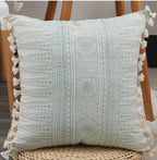 Decorative pillow with geometric pattern and tassels on a chair