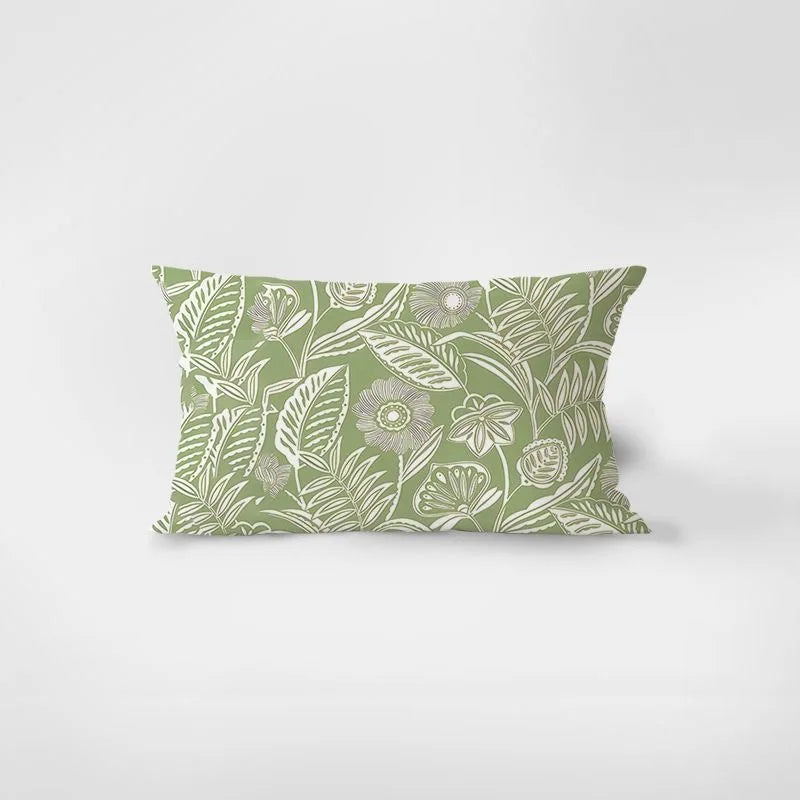 Decorative pillow with green and white floral pattern on a light gray background