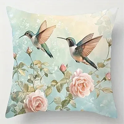 Decorative pillow with hummingbirds and flowers on a light blue background