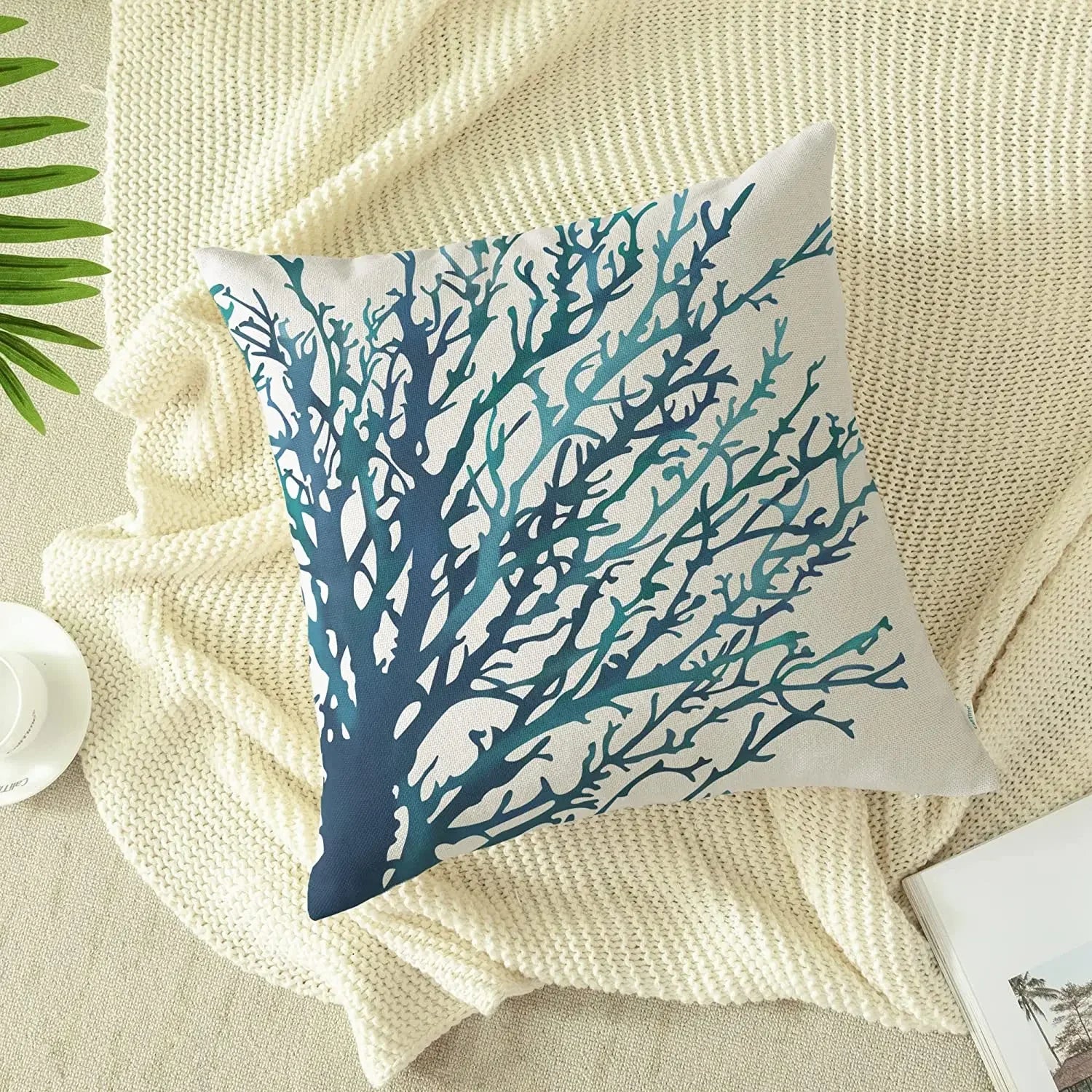 Decorative pillow with blue coral pattern on a textured surface
