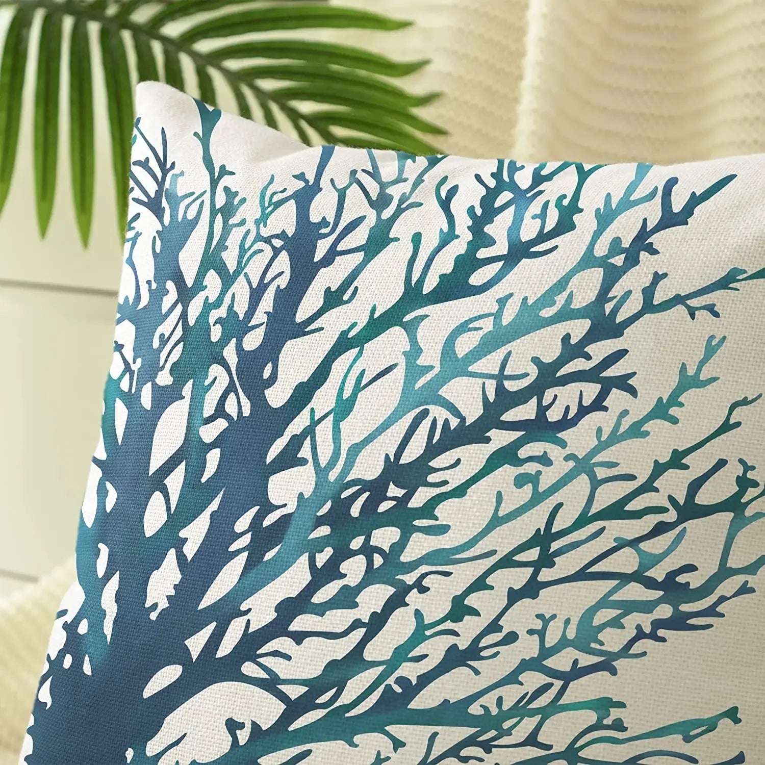 Decorative pillow with blue coral pattern on a neutral background