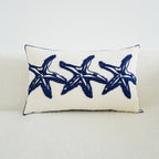 Decorative pillow with blue starfish pattern on a white background
