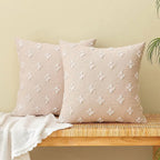 Two beige tufted pillows on wooden bench.