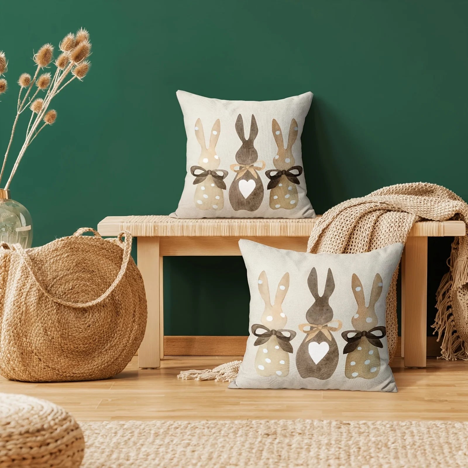 Decorative pillows with rabbit designs on a wooden surface against a green wall.