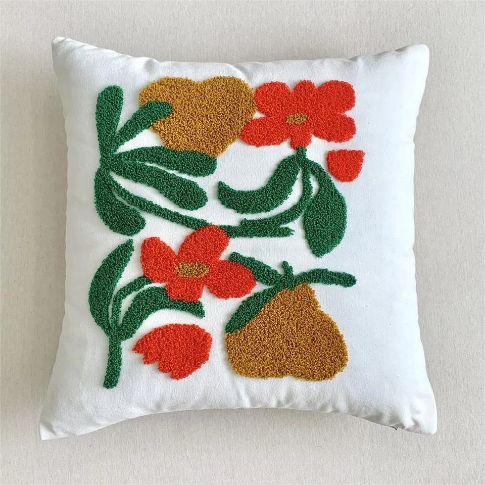 Decorative pillow with floral and leaf pattern on a plain background