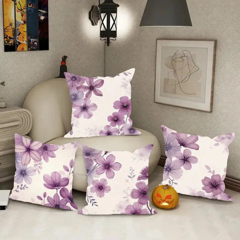 Floral patterned pillows on a sofa with a decorative pumpkin and wall art in the background.