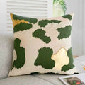 Decorative pillow with green leaf pattern on a neutral background