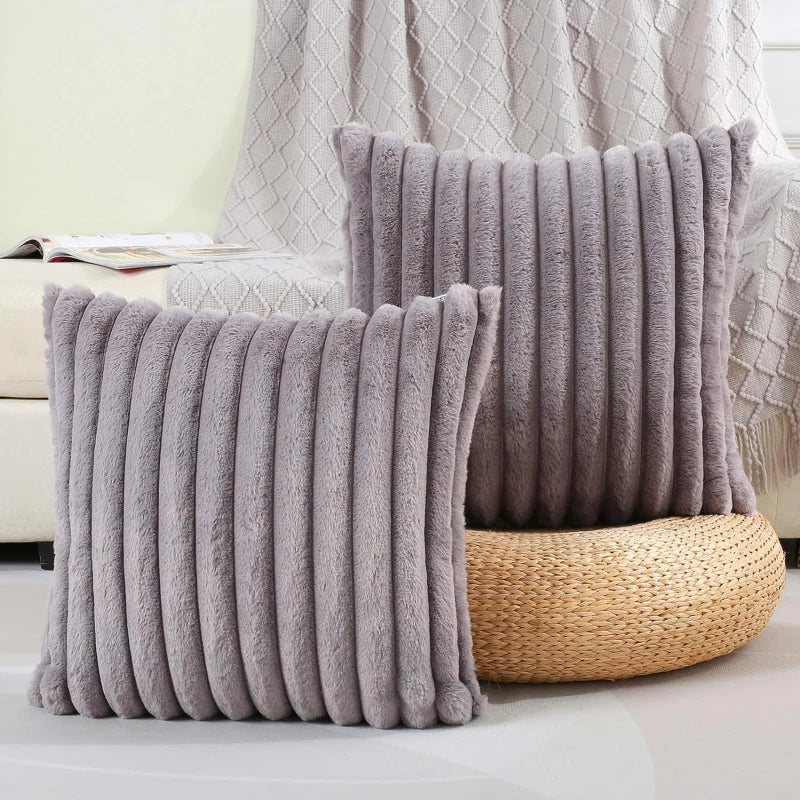 Two gray textured pillows on a couch with a neutral background