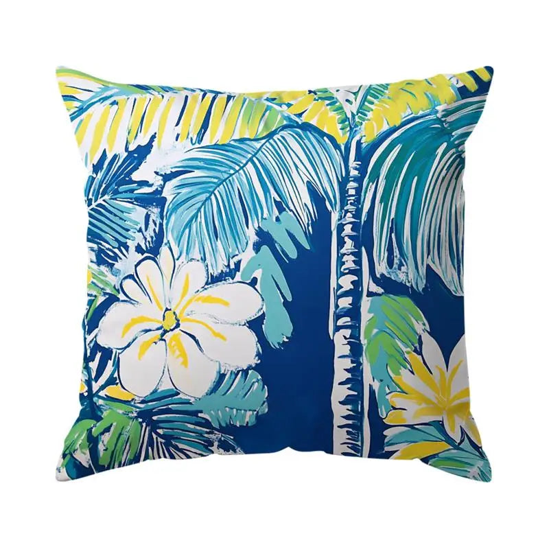 Decorative pillow with tropical leaf and flower pattern on a white background